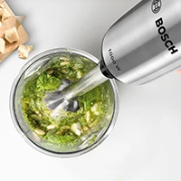 Bosch stavblender i sølv blender grøn pesto i glasskål på køkkenbord